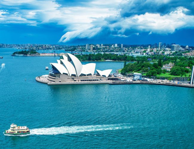 Aerial view of the iconic Sydney Opera House and Harbour with a ferry passing by.